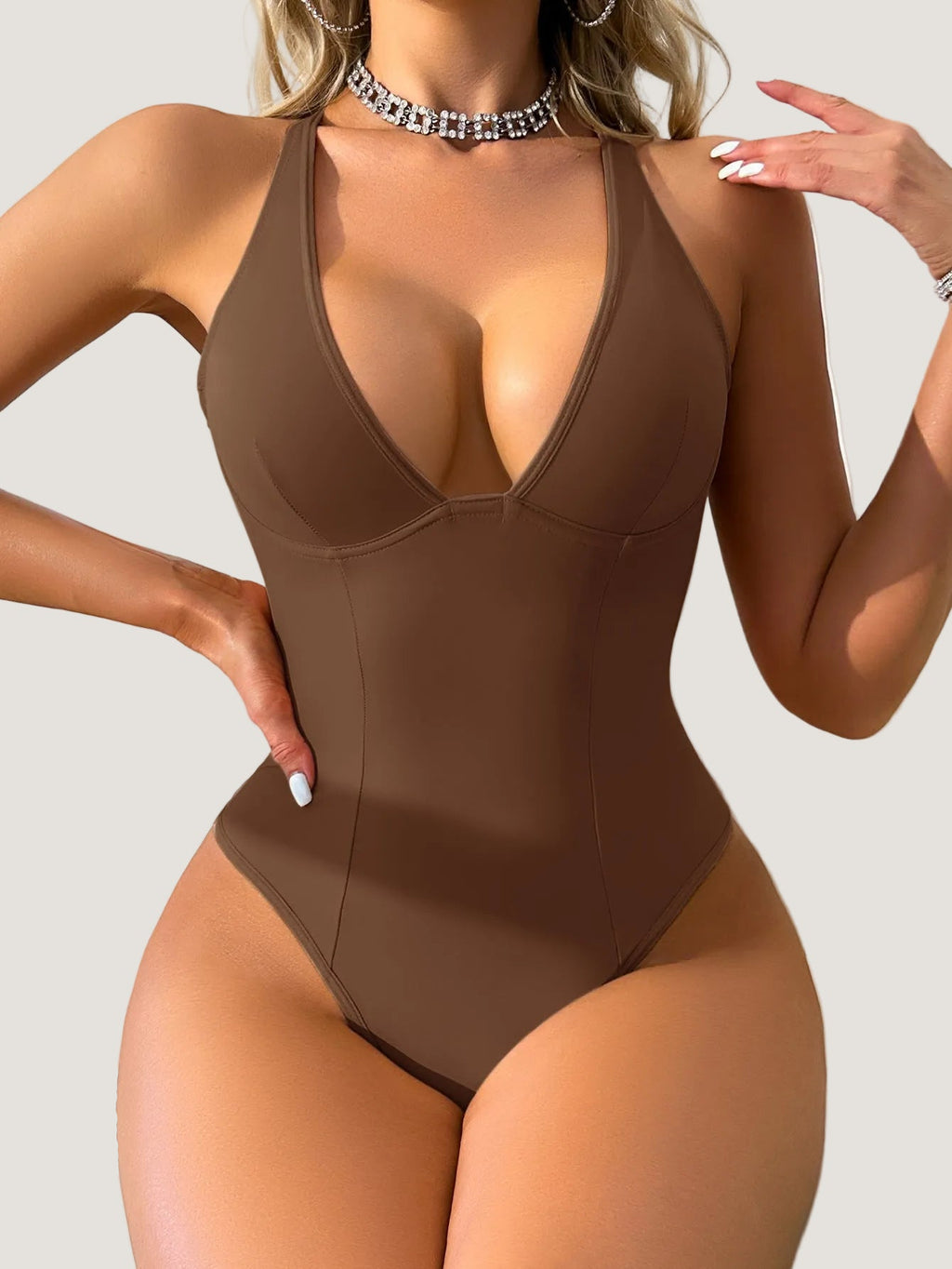 Brown swimsuit worn by a model against a neutral background