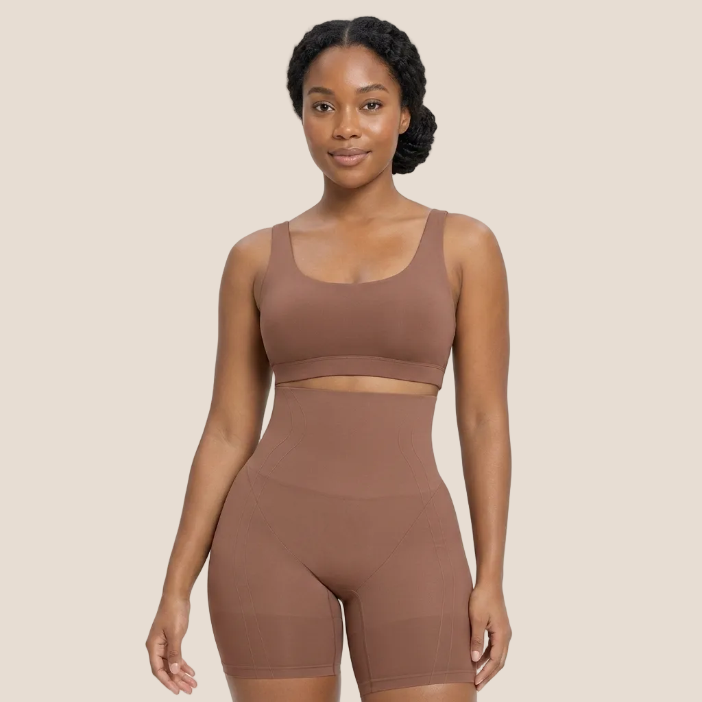 Woman wearing a brown sports bra and shorts set on a white background