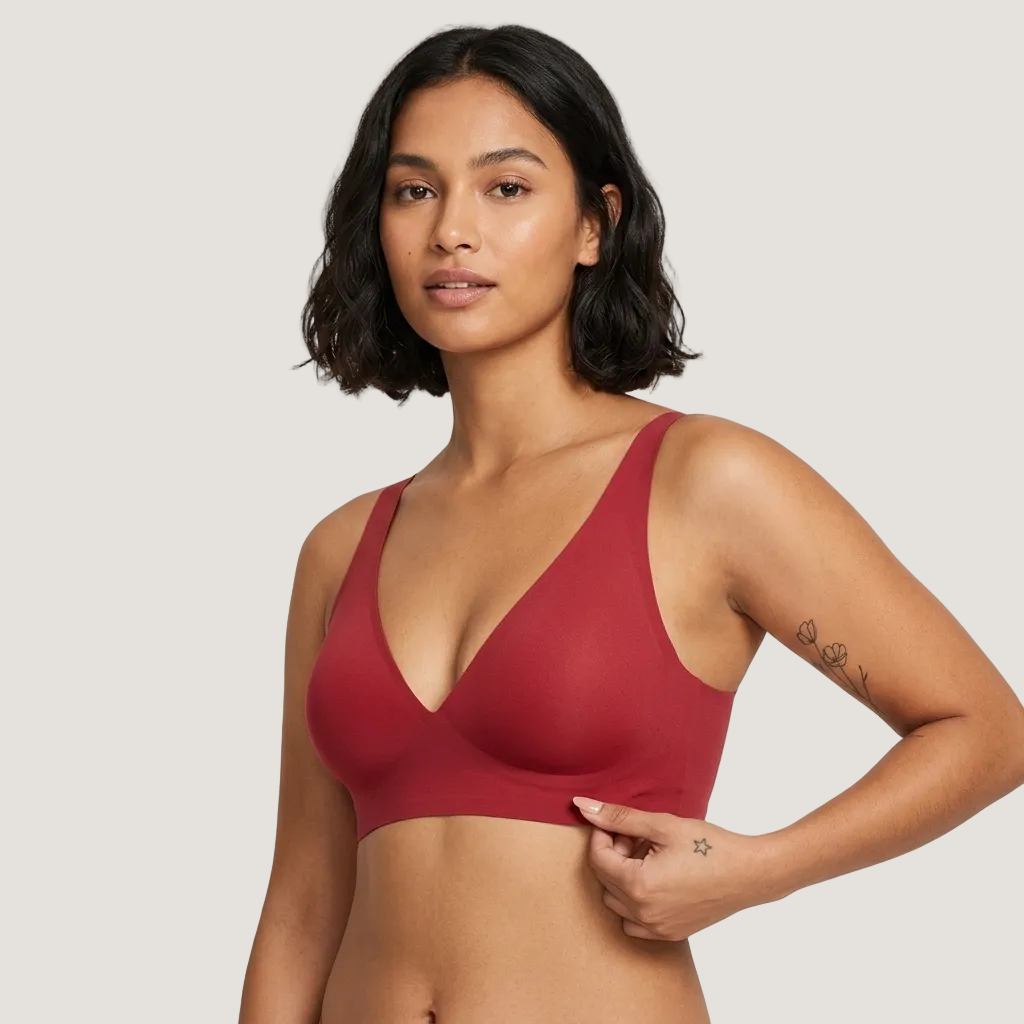 Woman wearing a red bralette against a plain background
