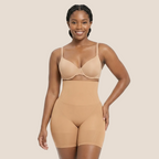 Woman wearing a beige shapewear bodysuit on a white background