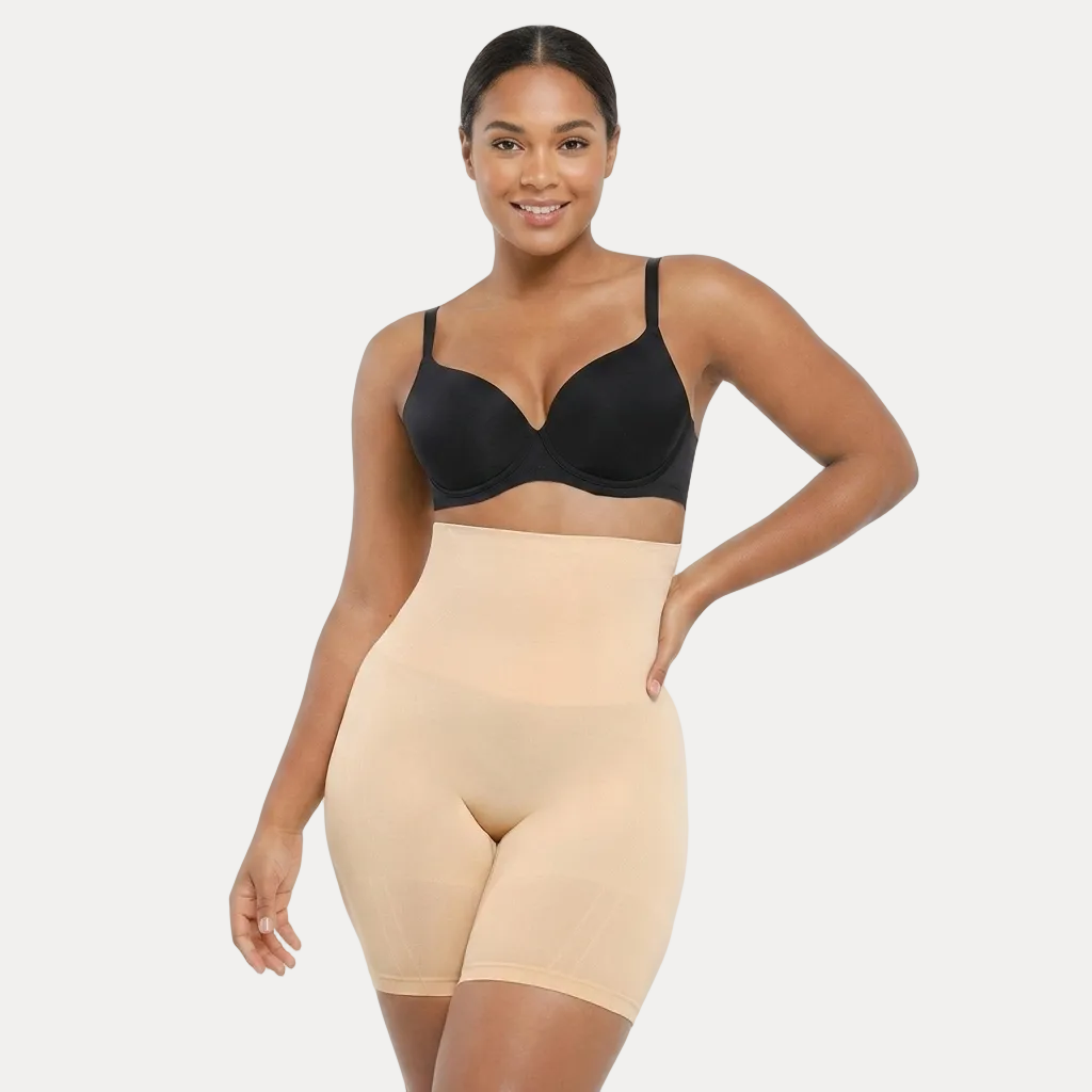 Woman wearing a black bra and beige shapewear on a white background