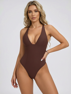 Woman wearing a brown swimsuit against a white background