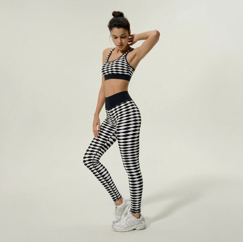 Woman wearing a black and white checkered sports bra and leggings set on a plain background