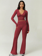 Woman wearing a burgundy long-sleeve top and flared pants on a white background