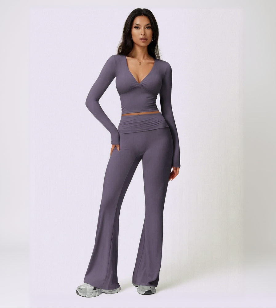 Woman wearing a purple long-sleeve top and pants set on a light purple background