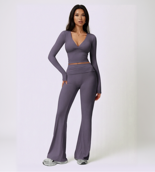 Woman wearing a purple long-sleeve top and pants set on a light purple background