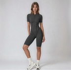 Woman wearing a gray bodysuit on a white background