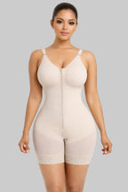 Woman wearing a beige shapewear bodysuit on a white background