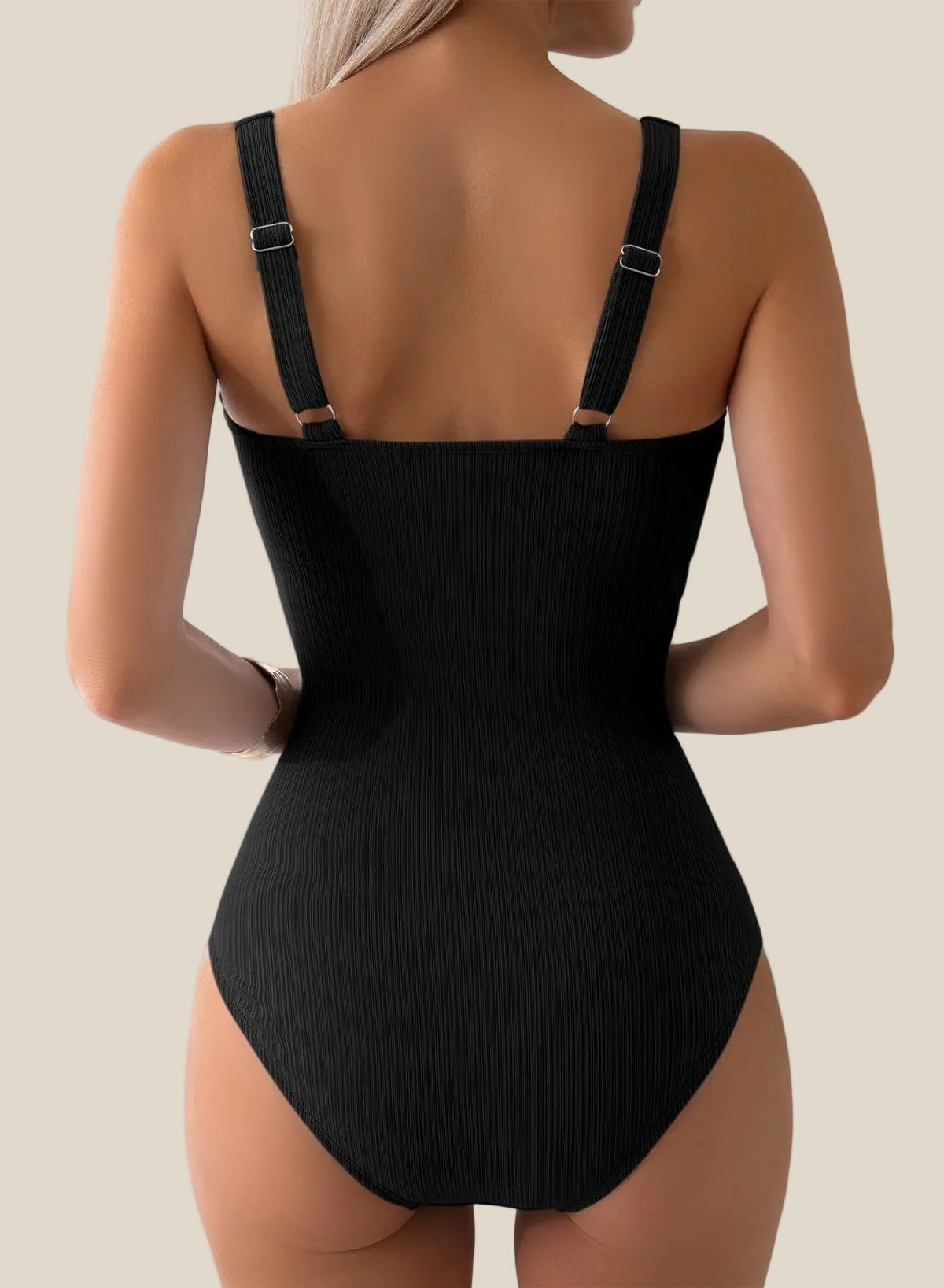 Black swimsuit with thin straps on a plain background