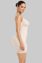 Woman wearing a beige shapewear dress on a white background